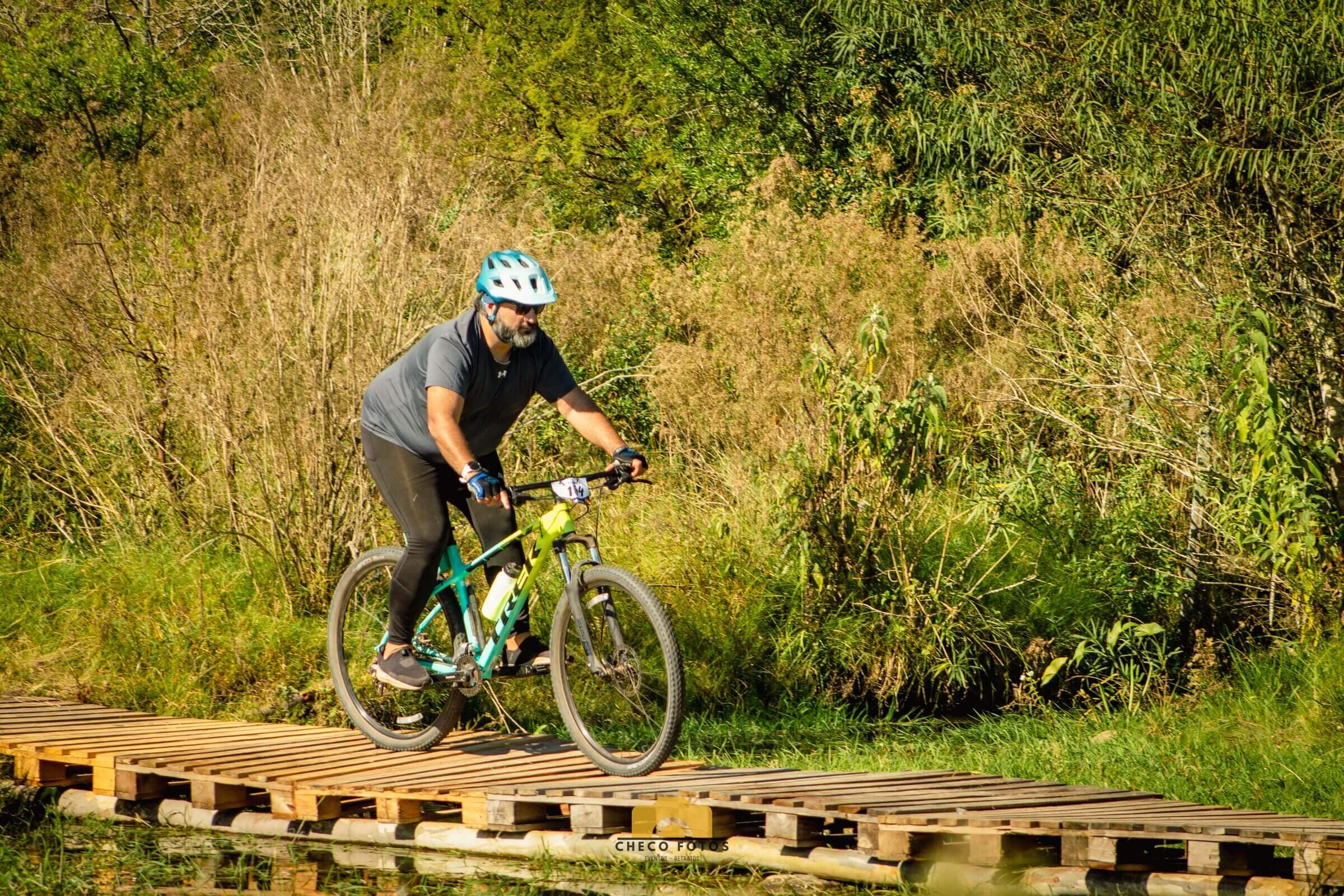 Ignacio “Nacho” Van Droogenbroeck mountain biking on a wooden boardwalk during a race